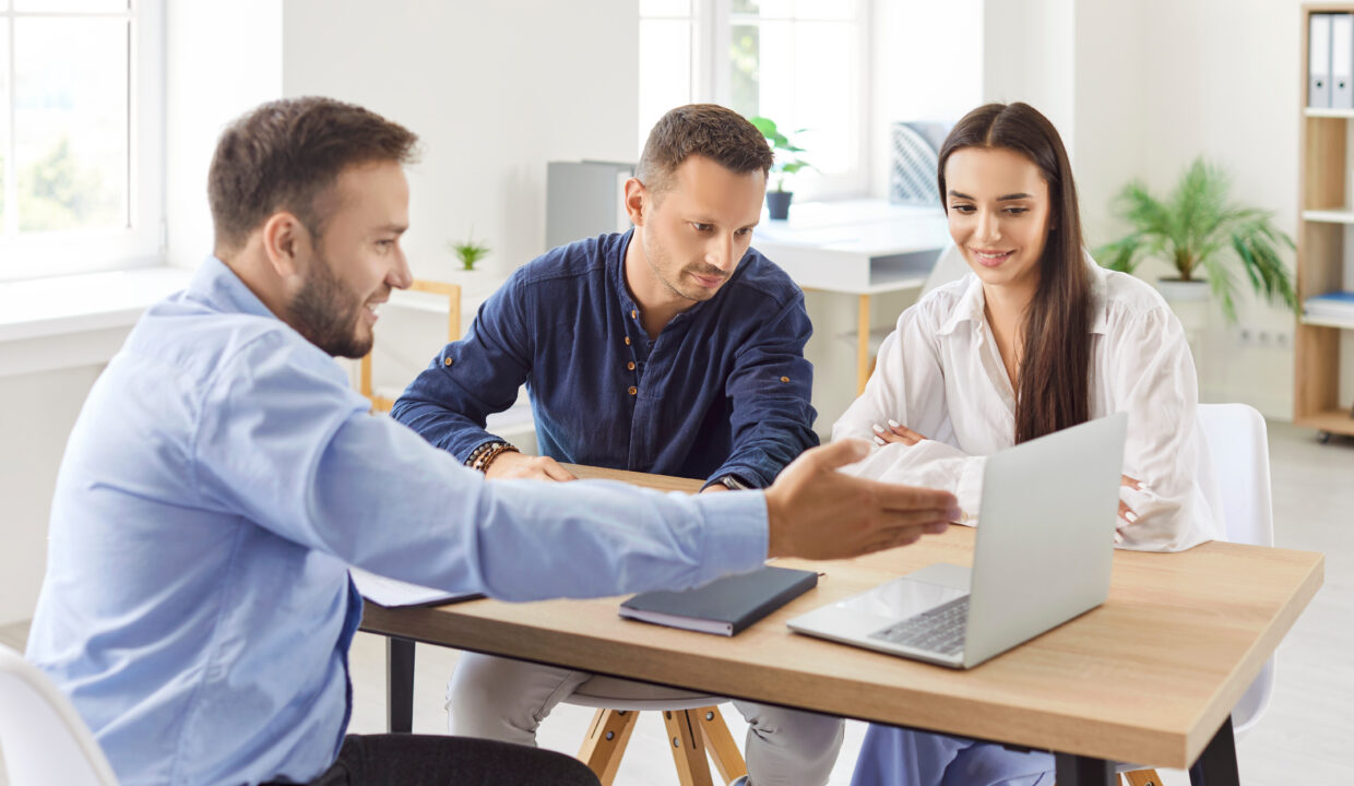 Deux colocataires qui sont conseillés par un professionnel de l'immobilier