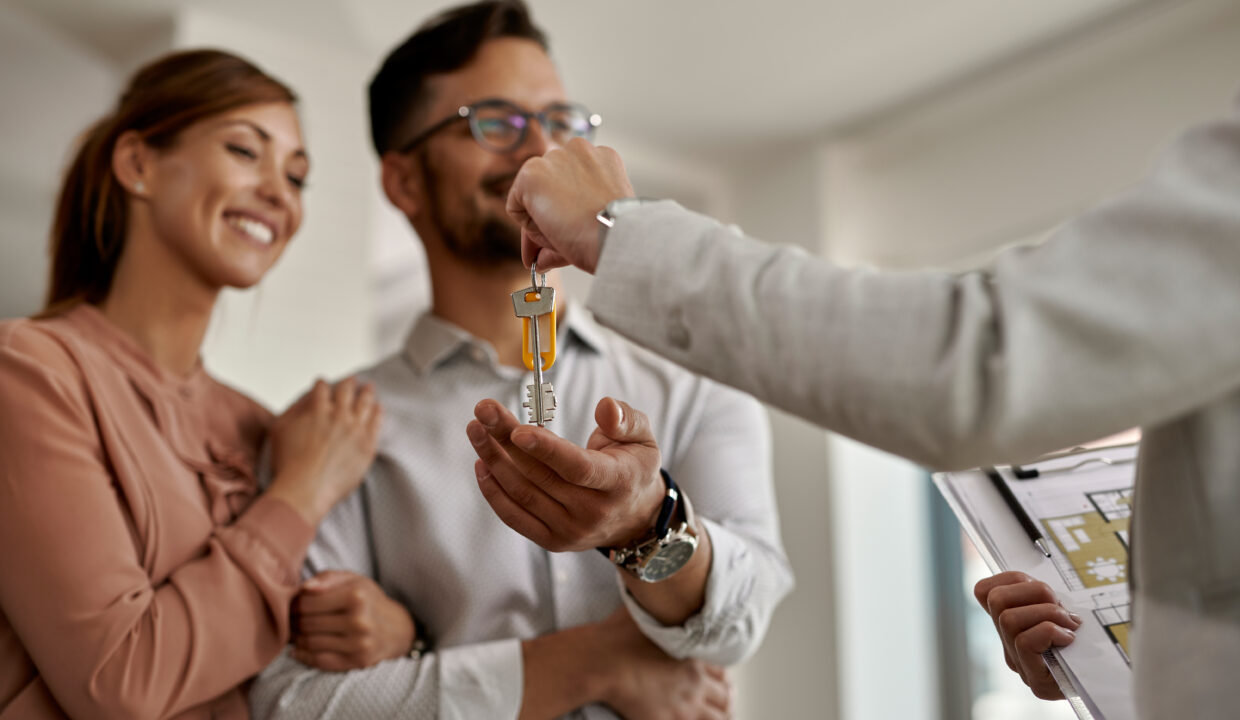 plan rapproché d'un agent immobilier donnant les clés de leur nouvelle maison
